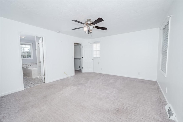 unfurnished bedroom featuring carpet, connected bathroom, a closet, visible vents, and baseboards