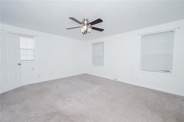 empty room with carpet floors, baseboards, and a ceiling fan