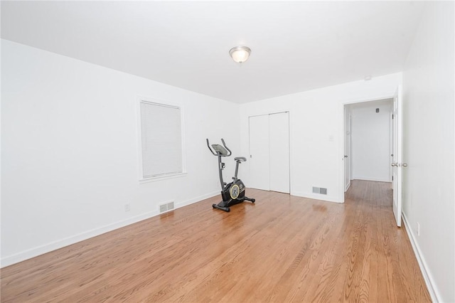 interior space featuring light wood-style flooring, baseboards, and visible vents