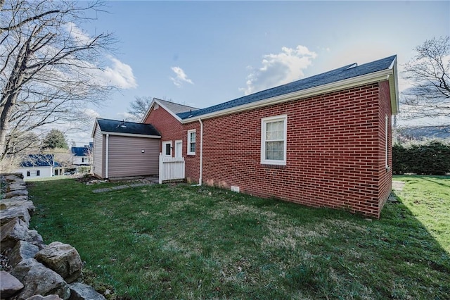 rear view of property with a yard and brick siding