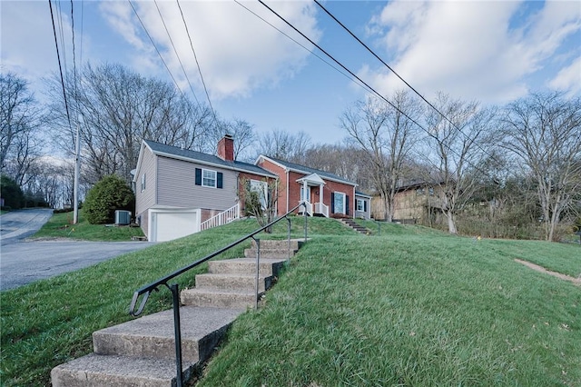 view of front of home with aphalt driveway, central air condition unit, a front lawn, an attached garage, and a chimney
