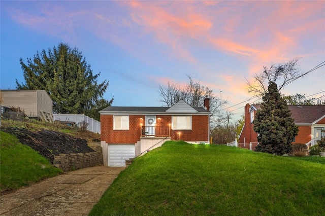 view of front facade with an attached garage, fence, concrete driveway, brick siding, and a front lawn