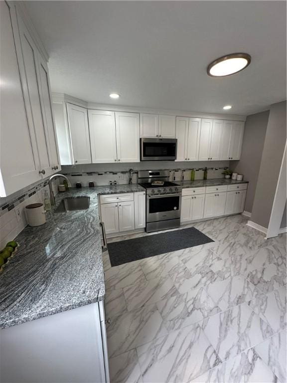 535 Grant Ave, Heidelberg, PA 15106 - kitchen featuring light stone countertops, a sink, stainless steel appliances, decorative backsplash, and baseboards