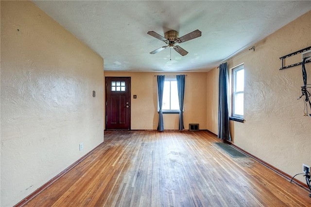 210 Verna Dr, Shaler, PA 15209 - interior space featuring a textured wall, wood-type flooring, a ceiling fan, and visible vents