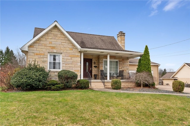 view of front of home featuring roof with shingles, a chimney, stone siding, a front lawn, and a porch