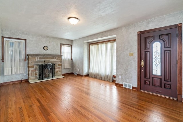 unfurnished living room featuring visible vents, baseboards, wood-type flooring, and a fireplace