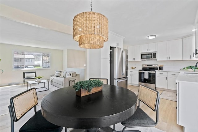 dining space with a chandelier and light wood-type flooring
