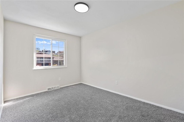 spare room featuring carpet flooring, baseboards, and visible vents