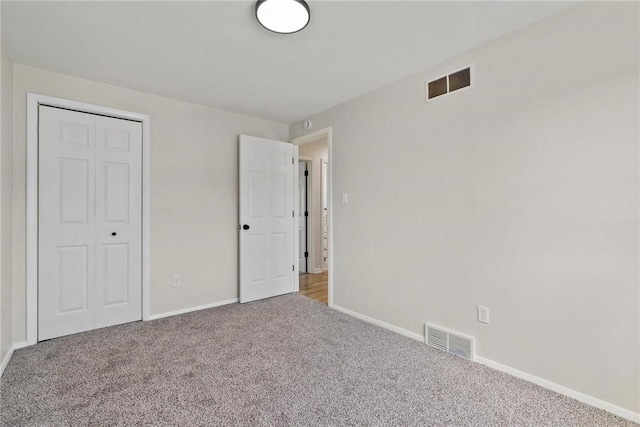unfurnished bedroom with baseboards, carpet, and visible vents