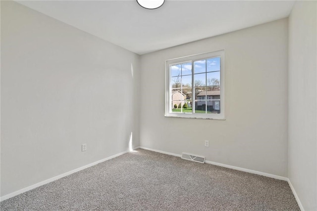 carpeted empty room featuring baseboards and visible vents