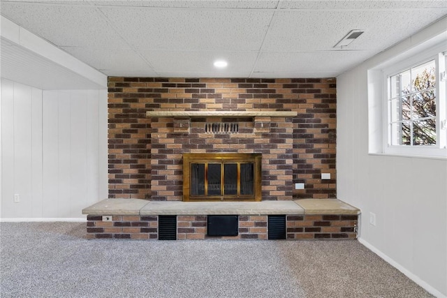 details featuring visible vents, a drop ceiling, carpet flooring, and a fireplace