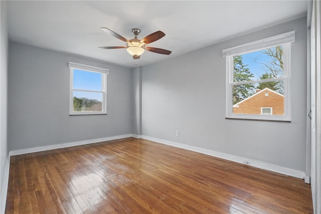 empty room with baseboards, hardwood / wood-style floors, and a ceiling fan