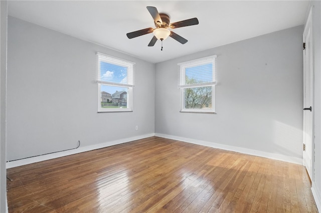 unfurnished room with hardwood / wood-style floors, ceiling fan, and baseboards