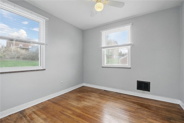 empty room with visible vents, baseboards, a ceiling fan, and wood finished floors