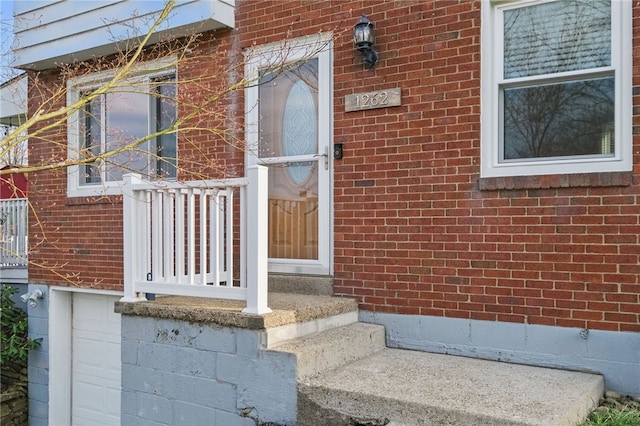 doorway to property featuring brick siding