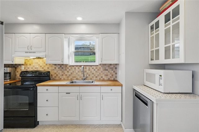 kitchen with white microwave, dishwasher, under cabinet range hood, black range with electric cooktop, and a sink
