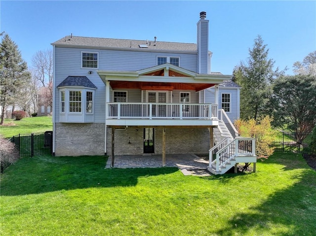 back of house featuring a yard, a chimney, a patio, and stairs