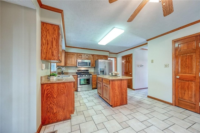 kitchen featuring brown cabinetry, ornamental molding, a center island, appliances with stainless steel finishes, and a sink