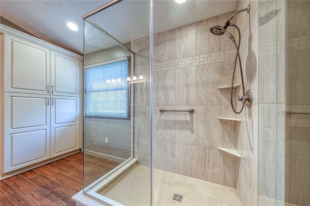 bathroom with a tile shower and wood finish floors