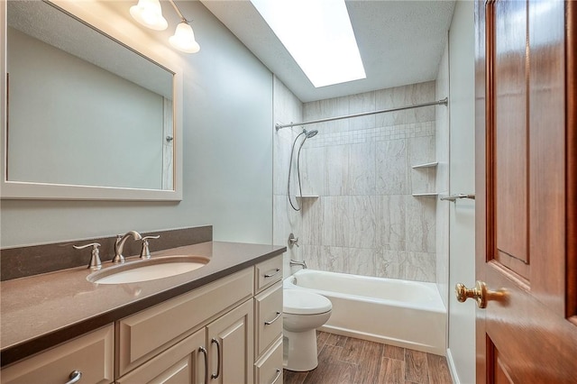 bathroom with toilet, vanity, wood finished floors, and  shower combination
