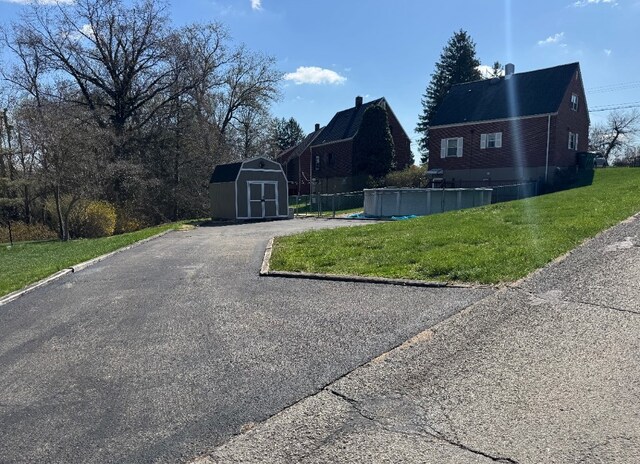 21 Garden Ter, Churchill Boro, PA 15221 - view of front facade with a storage shed, an outbuilding, and a front yard