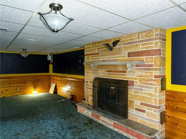 210 Locust St, Rural Valley Boro, PA 16249 - unfurnished living room with a paneled ceiling, wood walls, a stone fireplace, and carpet