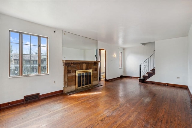 210 Morewood Rd, Shaler, PA 15116 - unfurnished living room featuring arched walkways, wood finished floors, stairs, baseboards, and visible vents
