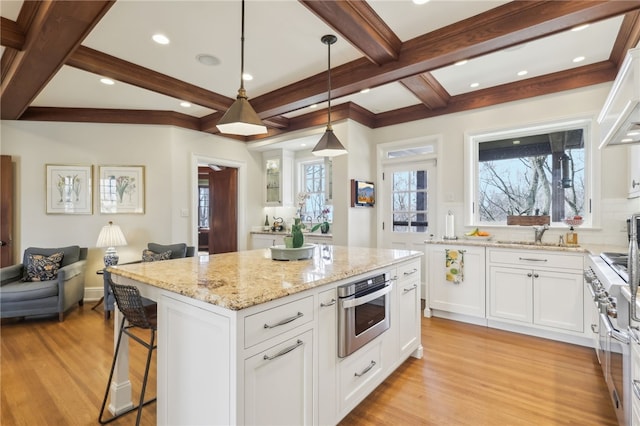 918 W Waldheim Rd, Fox Chapel, PA 15215 - kitchen with stainless steel appliances, light wood-style flooring, light stone counters, white cabinets, and beam ceiling