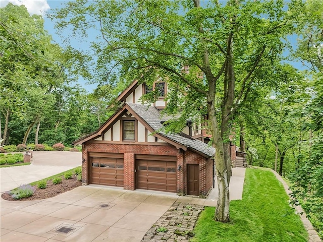 918 W Waldheim Rd, Fox Chapel, PA 15215 - view of front facade featuring a garage, brick siding, concrete driveway, and stucco siding