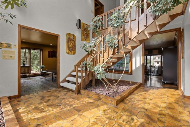 stairway with a towering ceiling and baseboards