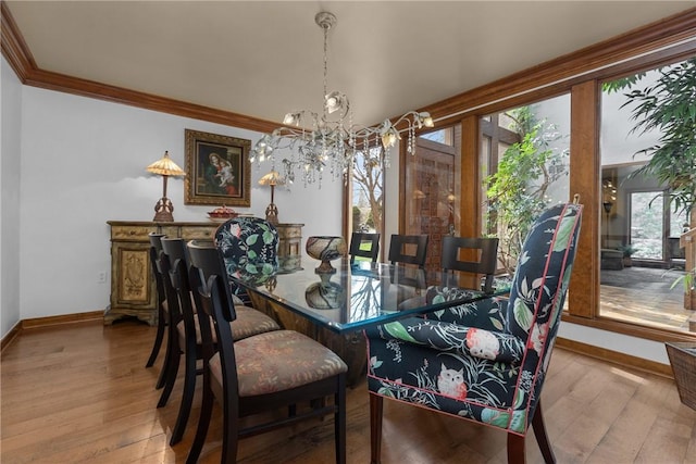 dining area with a chandelier, wood finished floors, baseboards, and ornamental molding