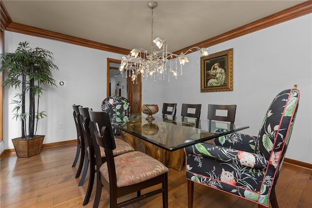 dining area with crown molding, baseboards, hardwood / wood-style floors, and a chandelier