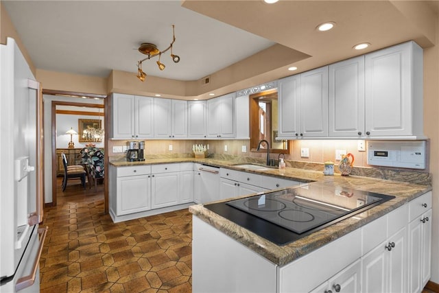 kitchen featuring a sink, black electric cooktop, and white cabinets