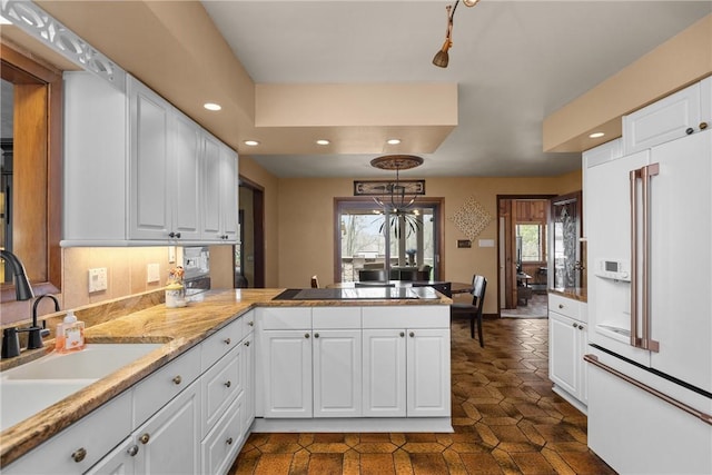 kitchen with a peninsula, white cabinetry, recessed lighting, a sink, and black electric cooktop