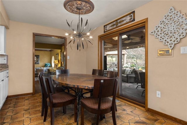 dining area with a chandelier and baseboards