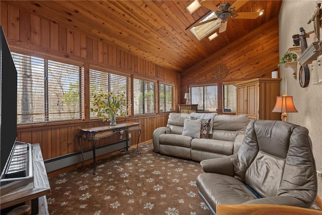living area featuring wood walls, ceiling fan, and baseboard heating