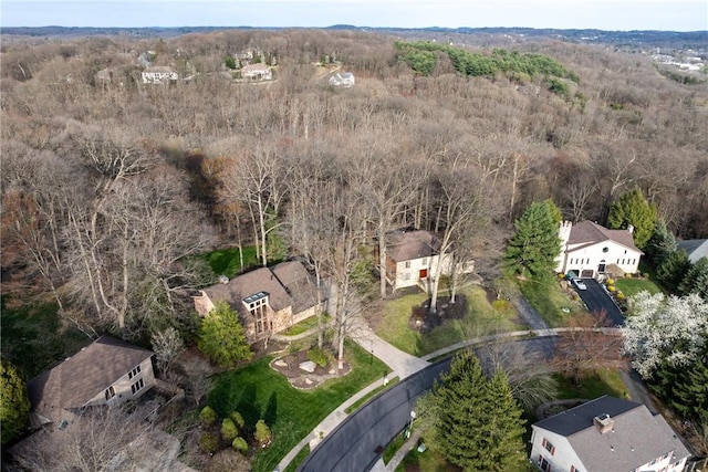 bird's eye view with a wooded view