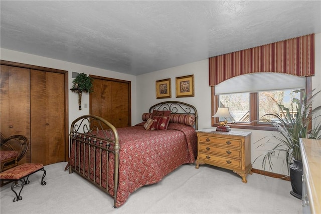 bedroom featuring multiple closets and light colored carpet