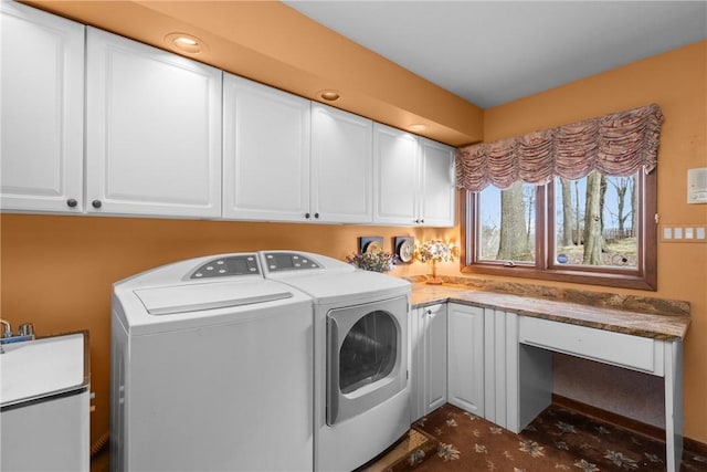 laundry area with independent washer and dryer and cabinet space