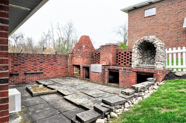 view of patio with an outdoor brick fireplace