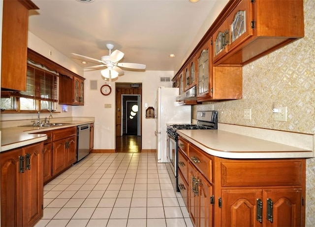 kitchen with light countertops, backsplash, a ceiling fan, appliances with stainless steel finishes, and a sink