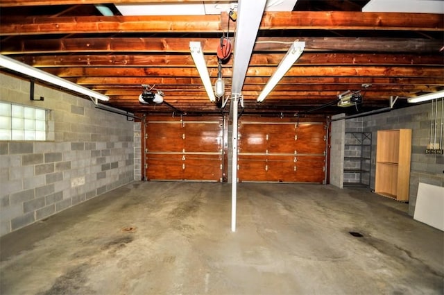garage with concrete block wall and a garage door opener