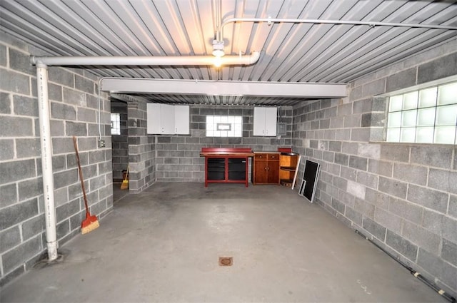 below grade area with a garage and concrete block wall