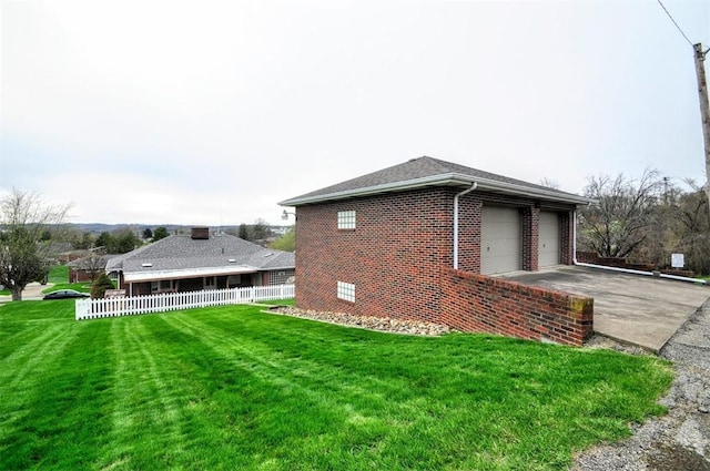 view of home's exterior featuring concrete driveway, brick siding, a garage, fence, and a lawn