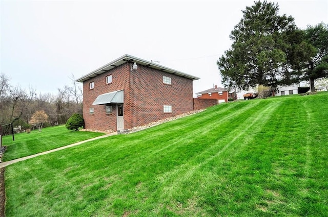 view of property exterior with a yard and brick siding