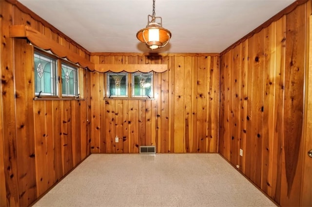 unfurnished room with visible vents, tile patterned floors, and wood walls