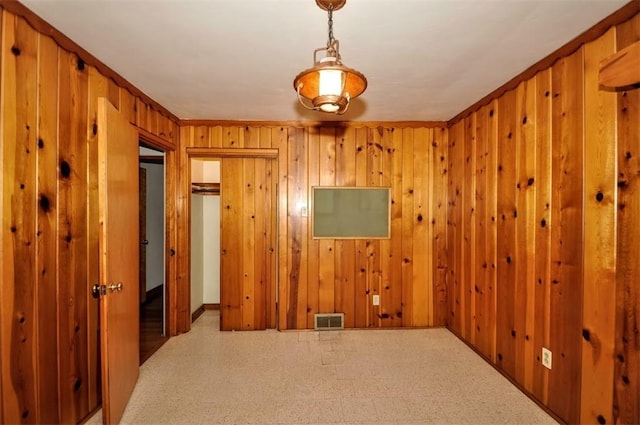 empty room featuring visible vents and wood walls