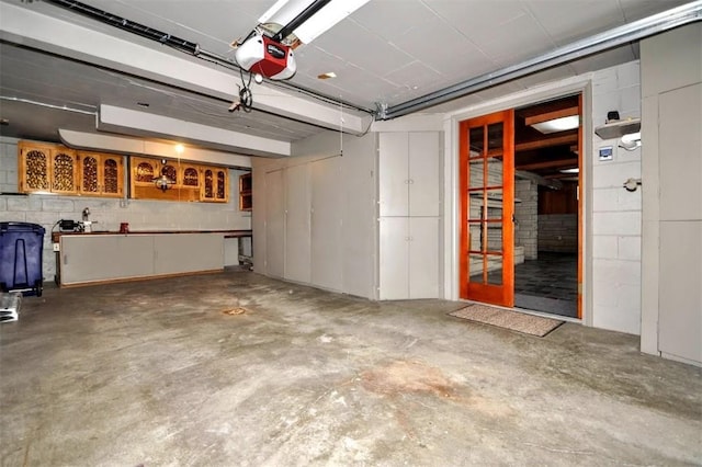 garage featuring a garage door opener and concrete block wall