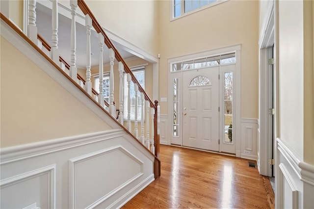 107 Stafford Ct, Ohio Twp, PA 15237 - entryway featuring light wood-style floors, a decorative wall, visible vents, wainscoting, and stairs