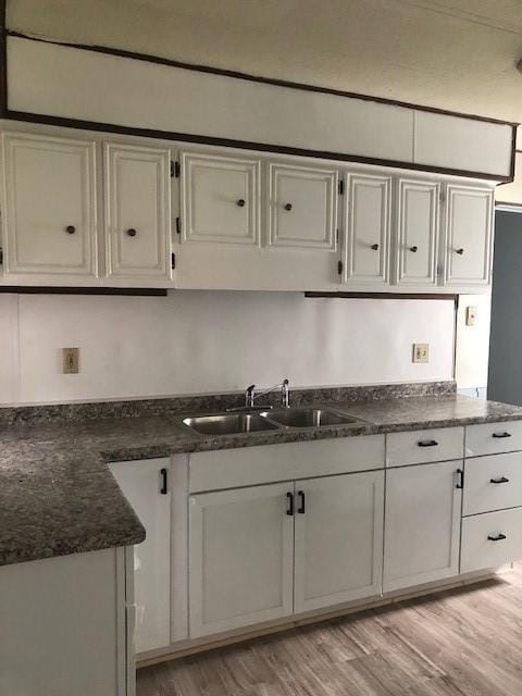 23 Gilmore Ln, Sandy Lake Twp, PA 16153 - kitchen featuring dark stone countertops, light wood finished floors, and a sink